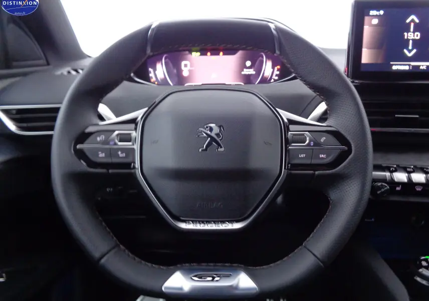 Volant cuir noir avec logo Peugeot et badge GT, tableau de bord numérique et écran central du Peugeot 3008 2023.