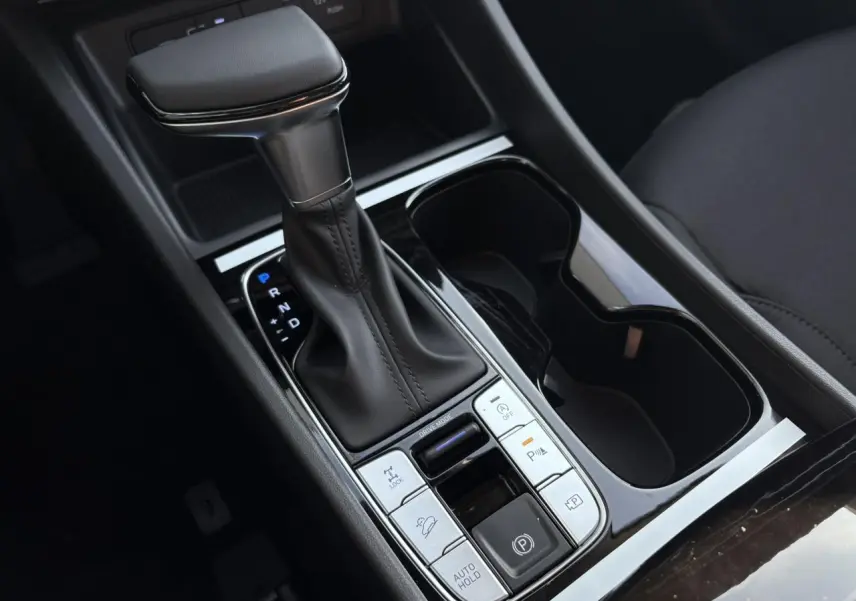 Gros plan sur la console centrale du Hyundai Tucson 2025, levier de vitesses automatique et commandes de conduite.