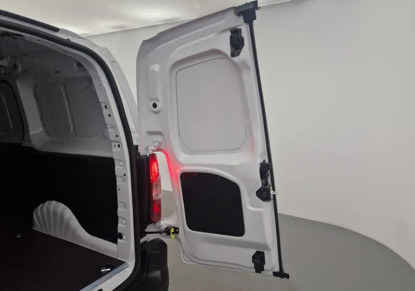 Vue arrière droite du Peugeot Partner blanc 2025 avec porte ouverte montrant l'espace de chargement vide.