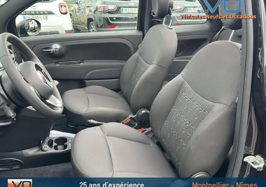 Vue intérieure côté droit montrant les sièges avant gris et le volant d'une FIAT 500C noire de 2024.