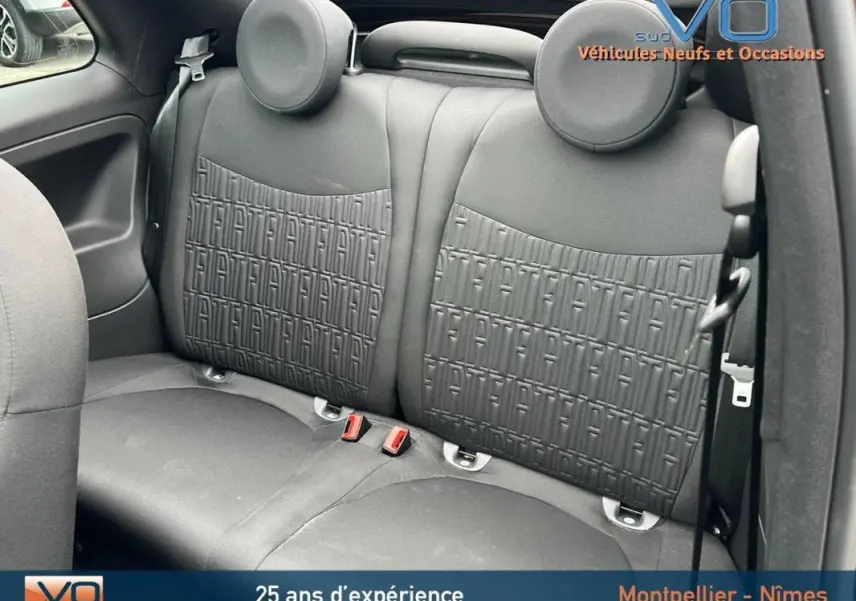 Vue intérieure sur la banquette arrière noire du Fiat 500C 2024 avec motifs FIAT embossés sur les dossiers.