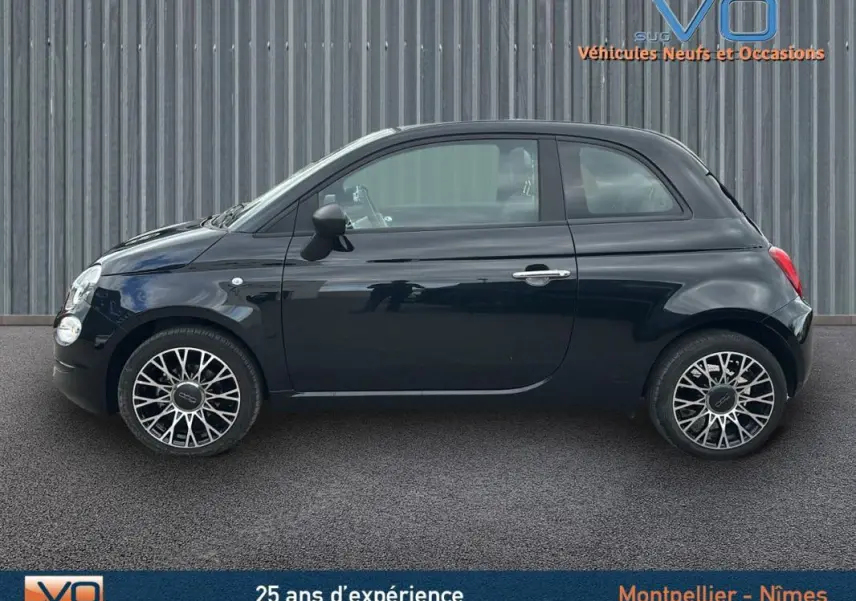 Profil côté gauche d'une FIAT 500C noire 2024 avec jantes stylisées et roue de secours visible.