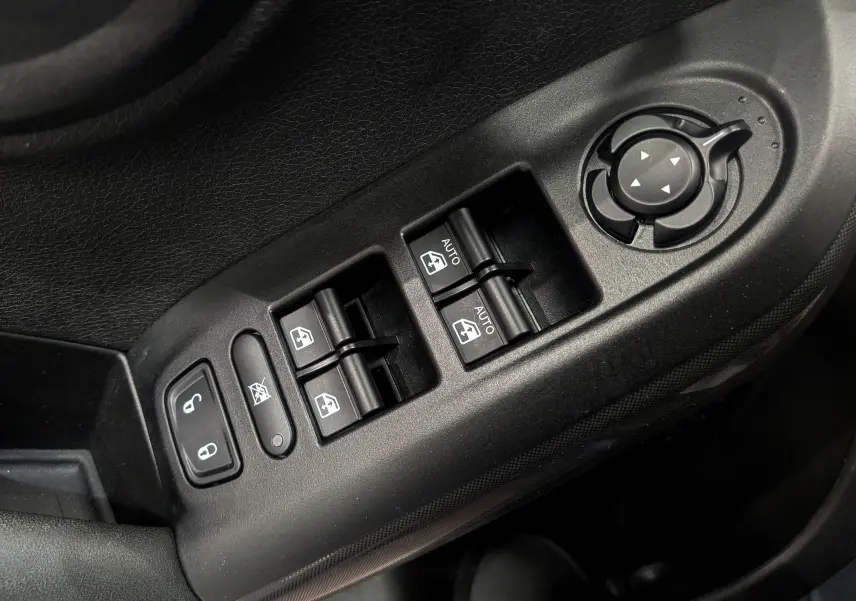 Gros plan sur les commandes électriques des vitres et rétroviseurs côté conducteur d'une Fiat 500X 2024, finition noire.