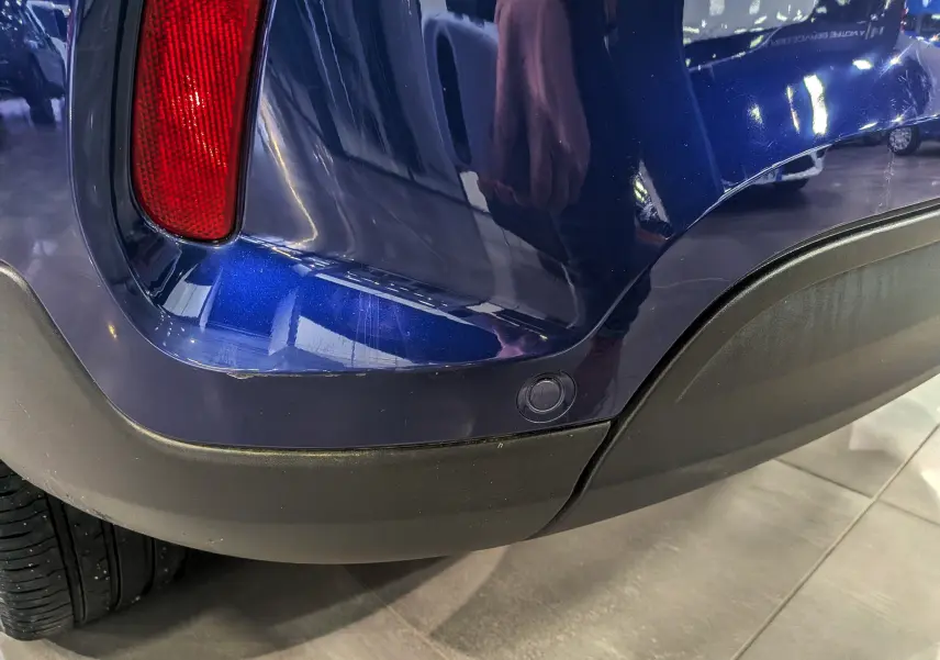 Détail du pare-chocs arrière droit bleu Venezia de la FIAT 500X 2024 avec feu rouge et capteur de stationnement.