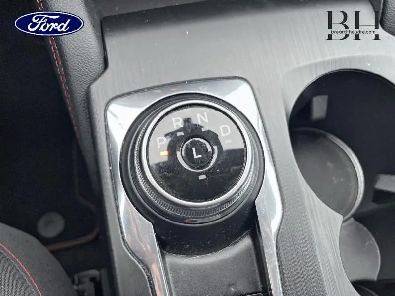 Vue rapprochée de la molette de sélection de la boîte automatique sur la console centrale du Ford Kuga gris métallisé.