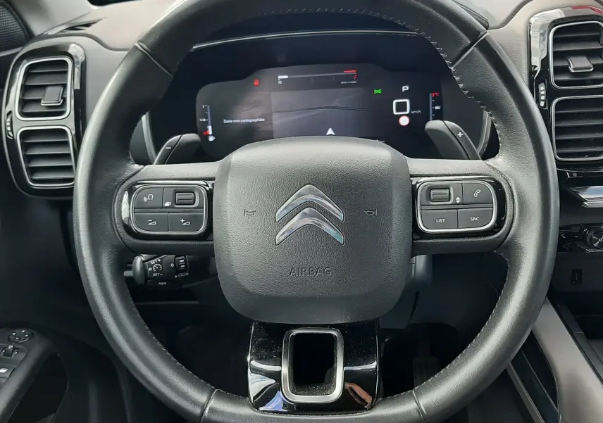 Vue rapprochée du volant noir de la Citroën C5 Aircross 2020 avec commandes intégrées et tableau de bord numérique.