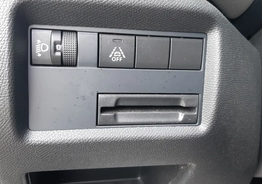 Détail intérieur montrant les commandes de réglage des phares et d'activation de l'alerte de franchissement de ligne sur Citroën C5 Aircross noir.