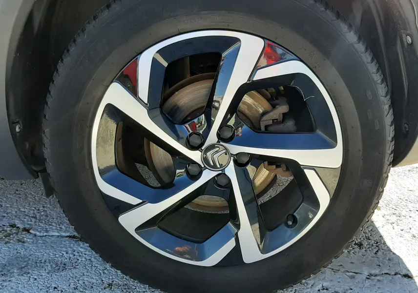 Gros plan sur la jante alliage bicolore noire et argentée avec logo Citroën au centre du Citroën C5 Aircross noir.