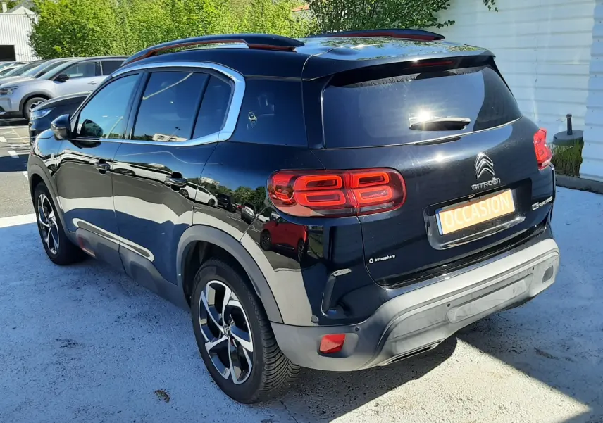 Vue 3/4 arrière droite d'un Citroën C5 Aircross noir 2020 avec feux arrière distinctifs et toit ouvrant panoramique.