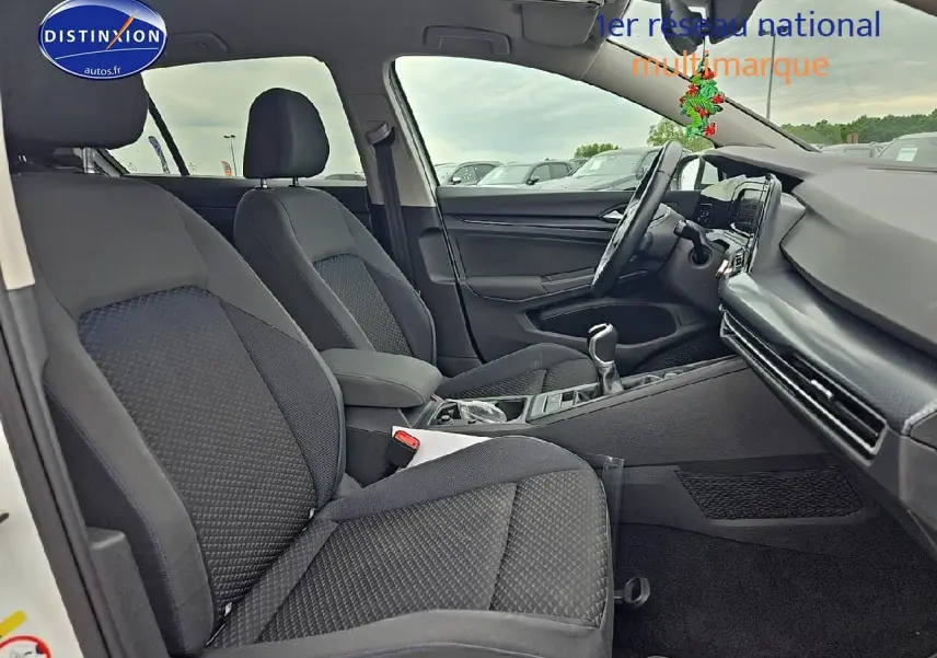 Vue intérieure côté droit de la Volkswagen Golf 1.5 TSI 2021 avec sièges tissu noirs et tableau de bord moderne.