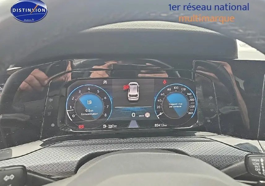 Vue du tableau de bord numérique de la Volkswagen Golf blanche, affichant la consommation et la vitesse à 0 km/h.