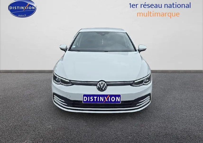 Vue frontale d'une Volkswagen Golf blanche 2021 avec phares LED et calandre épurée sur fond neutre.