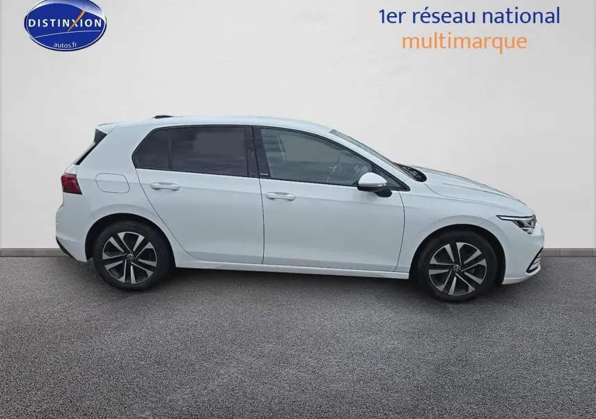 Profil droit d'une Volkswagen Golf blanche 2021 avec jantes alliage et vitres teintées sur fond neutre.