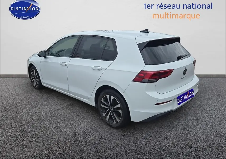 Vue 3/4 arrière droite d'une Volkswagen Golf blanche avec jantes alu et vitres teintées.