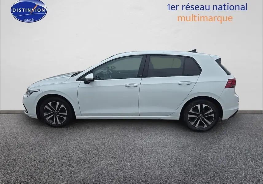 Profil droit d'une Volkswagen Golf blanche 2021 avec jantes alliage et vitres teintées sur fond neutre.