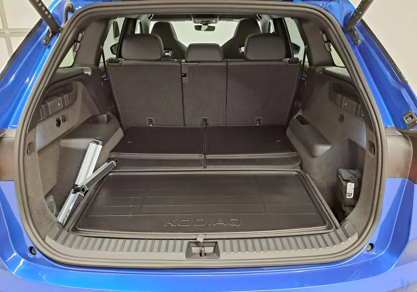 Vue arrière du coffre ouvert du Skoda Kodiaq Bleu RS 2025, montrant l'espace de chargement et la banquette arrière.