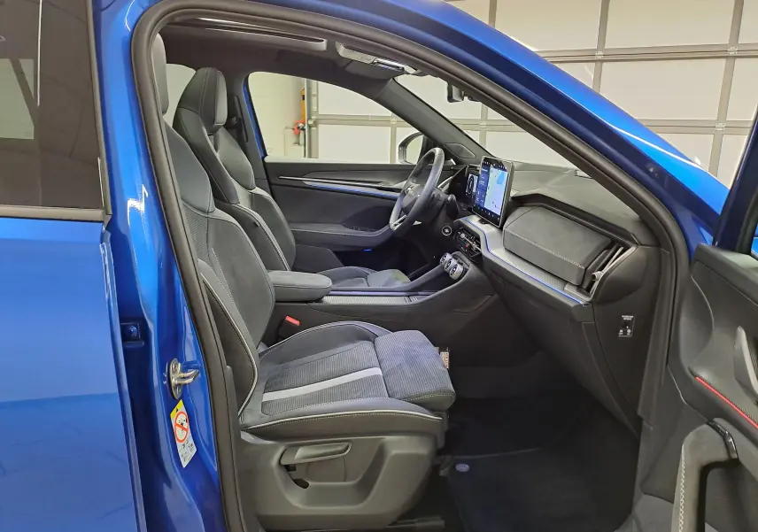 Vue intérieure côté conducteur du Skoda Kodiaq Bleu RS 2025, mettant en valeur les sièges sport et le tableau de bord moderne.