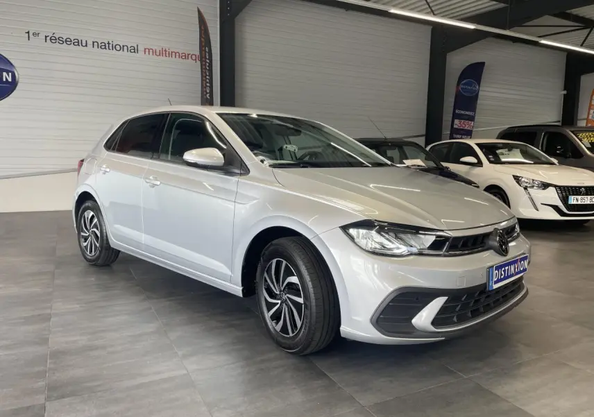 Volkswagen Polo gris clair vue 3/4 avant droit en intérieur avec jantes alliage et calandre chromée.