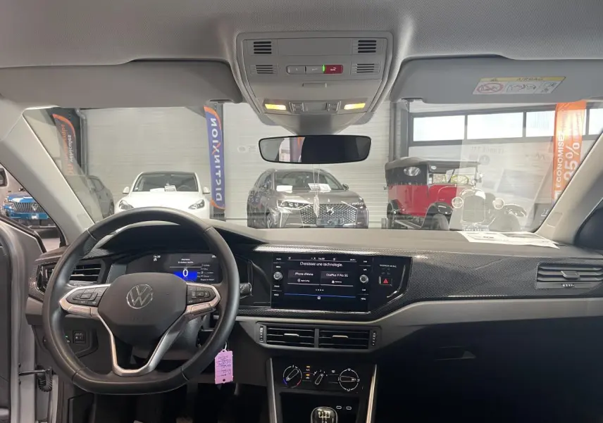 Vue intérieure avant du tableau de bord et volant cuir multifonction de la Volkswagen Polo gris clair 2024.
