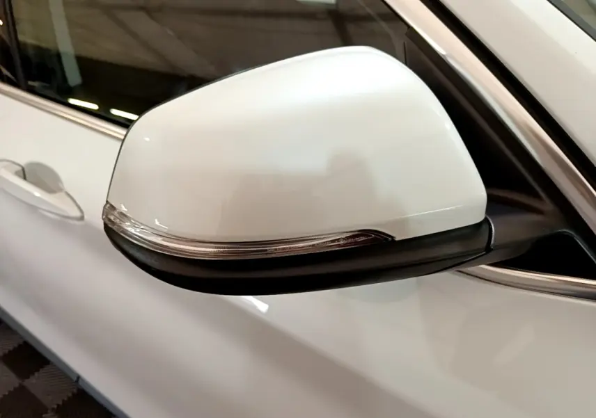 Gros plan sur le rétroviseur droit blanc avec clignotant intégré du BMW X1 sDrive18i Lounge 2019.