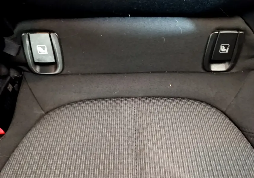 Gros plan sur les commandes de rabattement des sièges arrière du BMW X1 sDrive18i Lounge 2019, tissu gris.