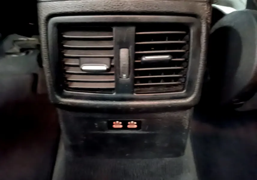 Détail des bouches d’aération arrière et prises USB illuminées dans l’habitacle noir du BMW X1 sDrive18i Lounge 2019.