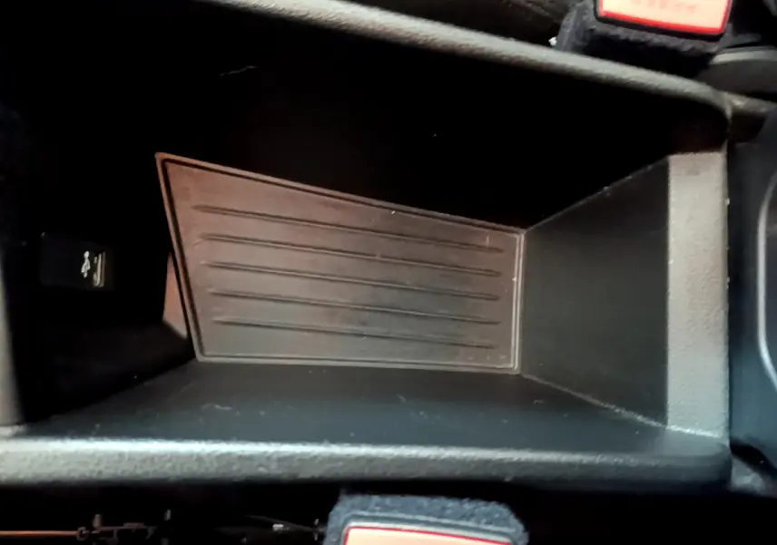 Gros plan sur le rangement central noir de la BMW X1 sDrive18i Lounge 2019, avec bouton USB visible à gauche.