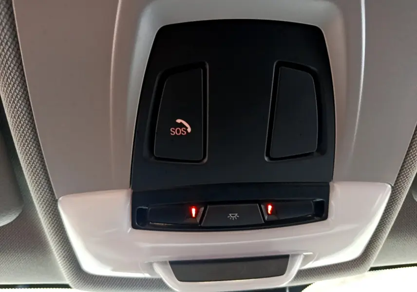 Gros plan sur les commandes de plafonnier et bouton SOS du toit intérieur du BMW X1 sDrive18i blanc de 2019.