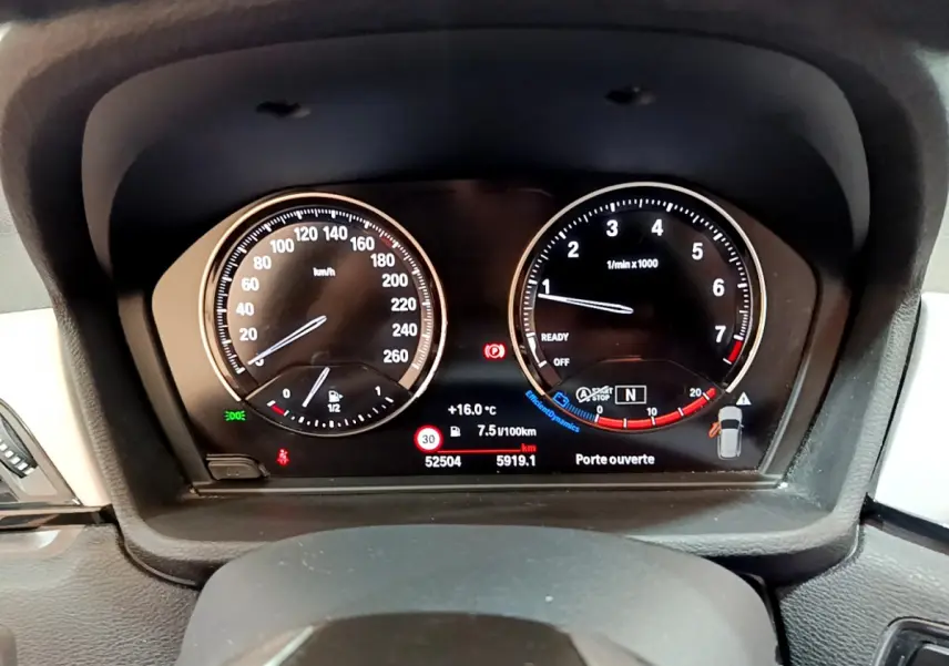 Vue rapprochée du tableau de bord numérique de la BMW X1 sDrive18i Lounge 2019 affichant vitesse et compte-tours.