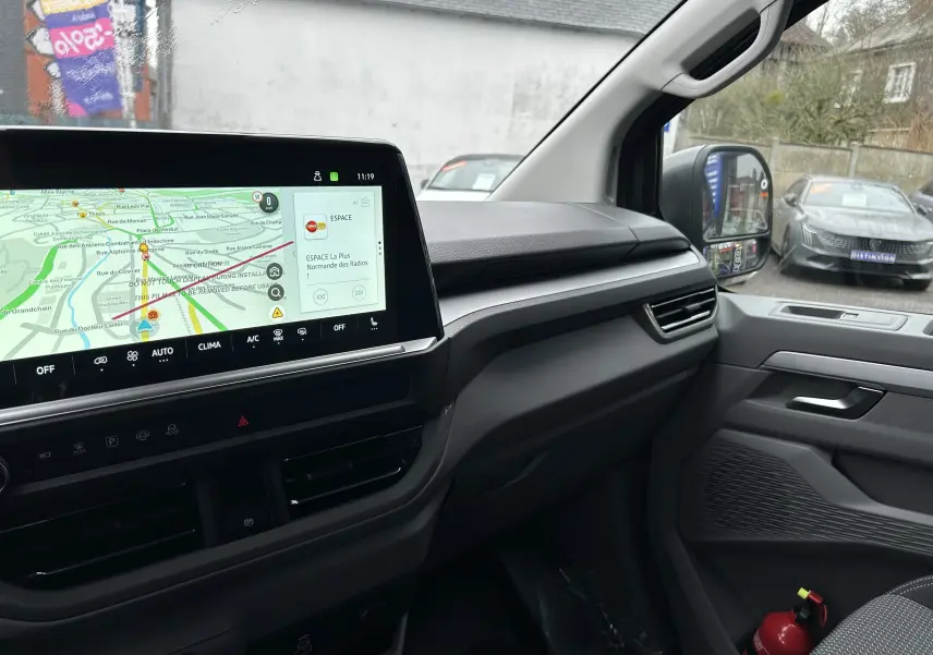 Vue intérieure côté passager du Volkswagen Transporter T7 Business 2026 avec écran tactile et sellerie tissu gris.