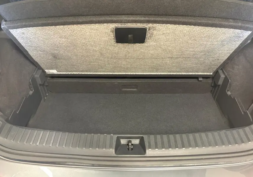 Coffre ouvert d’un Skoda Kodiaq gris graphite 2025, vue plongeante sur l’espace de rangement vide.