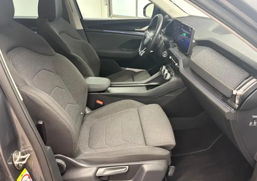 Intérieur côté conducteur du Skoda Kodiaq 2025 gris graphite, avec sièges tissu et tableau de bord moderne équipé d’un écran tactile.
