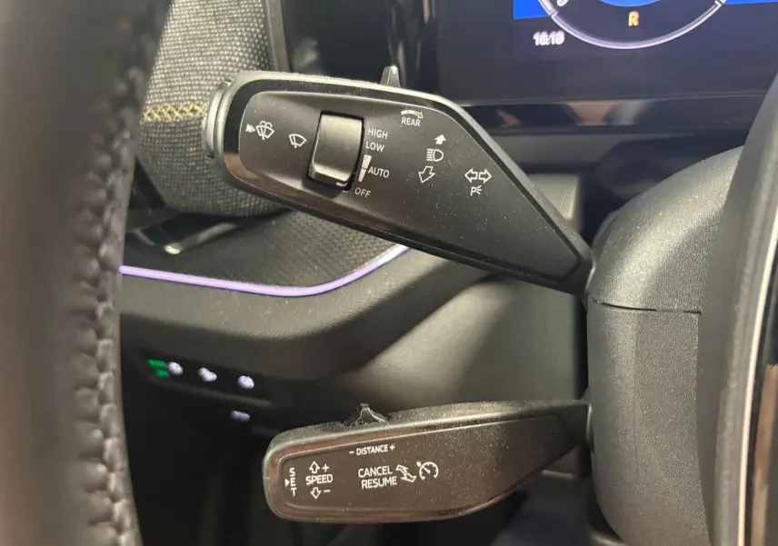 Gros plan sur les commandes au volant du Skoda Kodiaq 2025, avec leviers de clignotants et régulateur de vitesse.