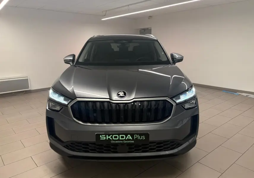 Vue frontale d'un Skoda Kodiaq gris graphite 2025 avec calandre noire et phares LED allumés en intérieur.