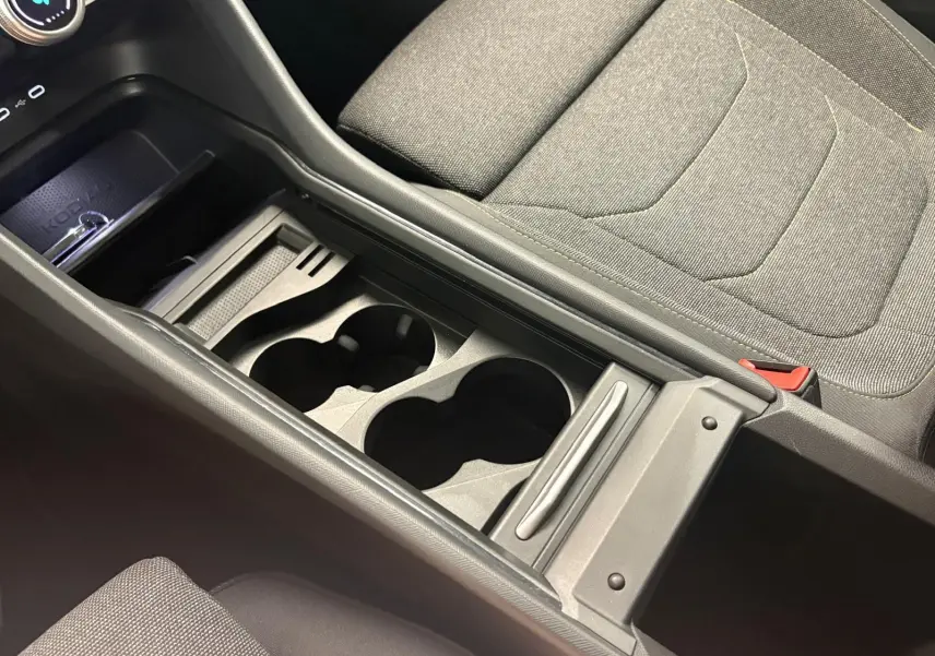 Vue rapprochée de la console centrale grise avec porte-gobelets et siège tissu gris du Skoda Kodiaq 2025.