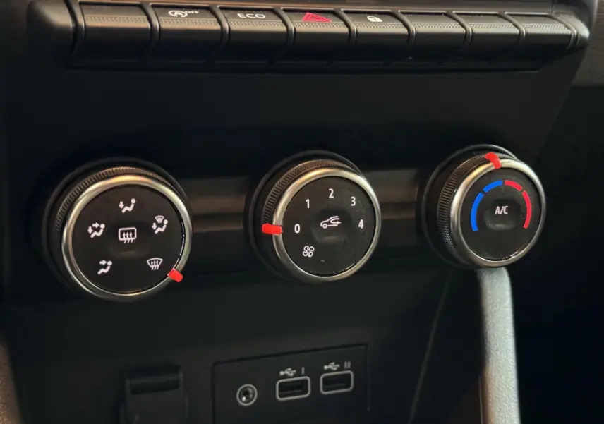 Gros plan sur les commandes de climatisation et les ports USB du tableau de bord de la Renault Clio gris clair Evolution Blue dCi 100 2025.