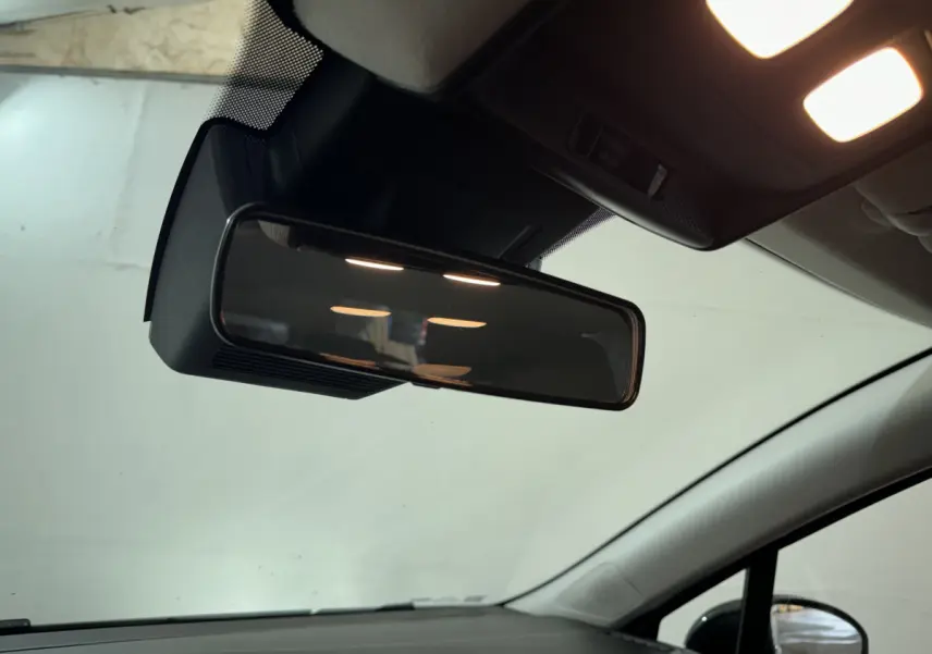 Vue intérieure rapprochée du rétroviseur central et du plafonnier éclairé d'une Renault Clio gris clair 2025.