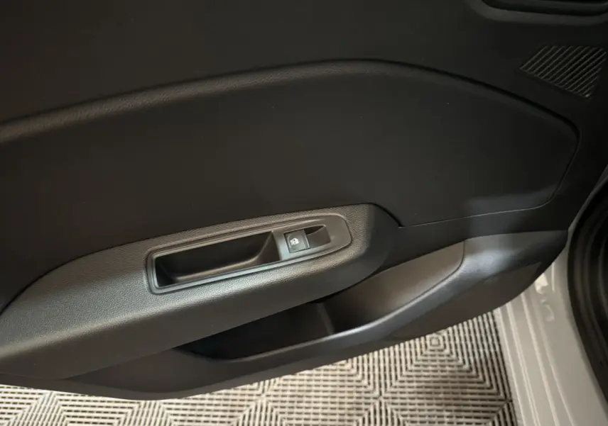 Gros plan sur la poignée intérieure de la porte côté gauche d'une Renault Clio gris clair Evolution Blue dCi 100 2025.