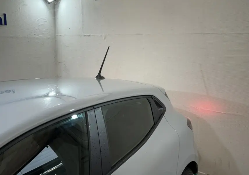 Vue arrière côté gauche d'une Renault Clio gris clair 2025, avec antenne de toit et vitres teintées.