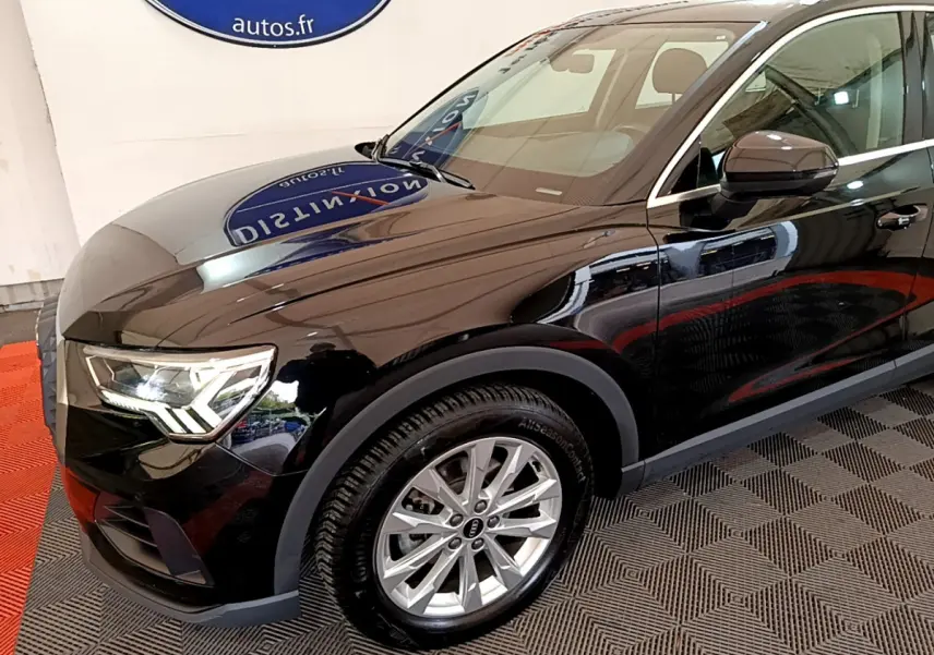 Audi Q3 noir vue 3/4 avant droit, mettant en valeur les phares LED et les jantes alliage argentées.