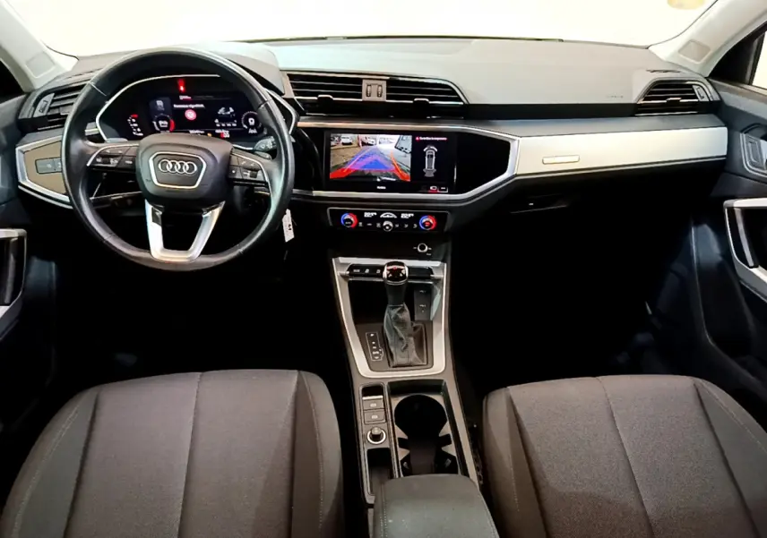 Vue intérieure avant de l'Audi Q3 35 TDI 2021 avec tableau de bord numérique et écran tactile central allumé.