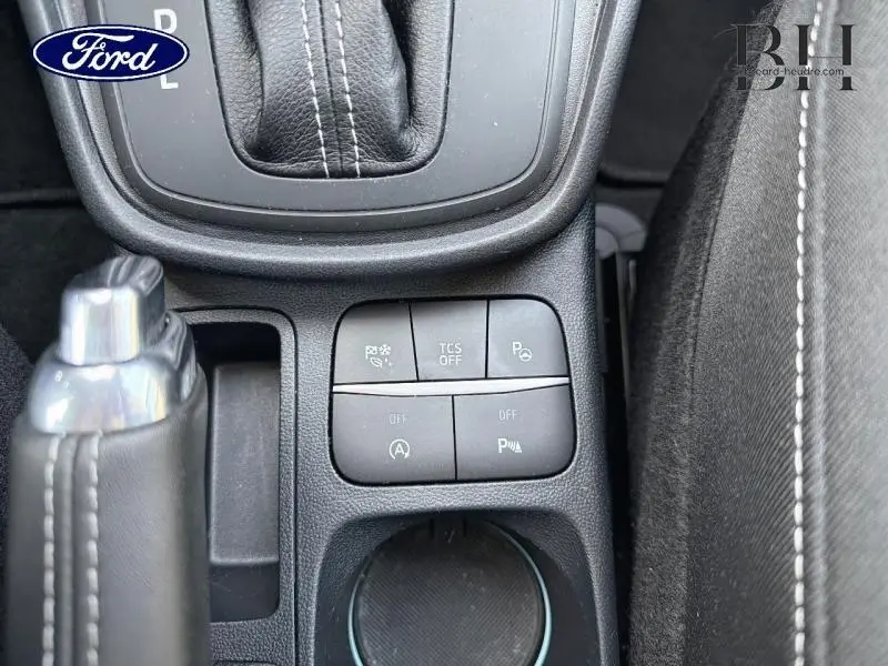 Vue rapprochée de la console centrale du Ford Puma 2020, montrant les boutons de sécurité et le levier de frein à main cuir noir.