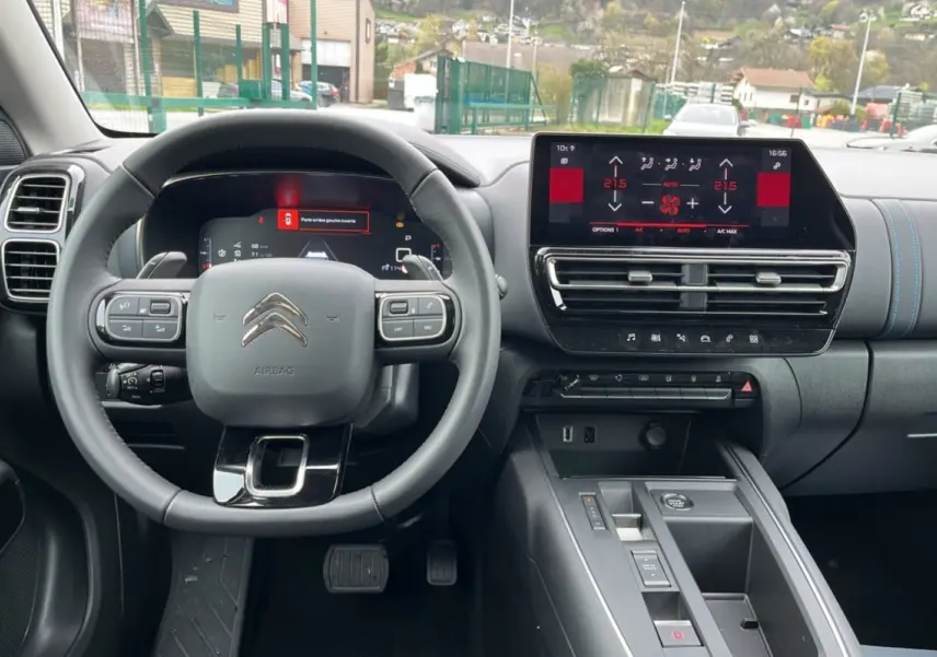 Vue intérieure centrée sur le volant cuir multifonctions et l’écran tactile du tableau de bord du Citroën C5 Aircross.
