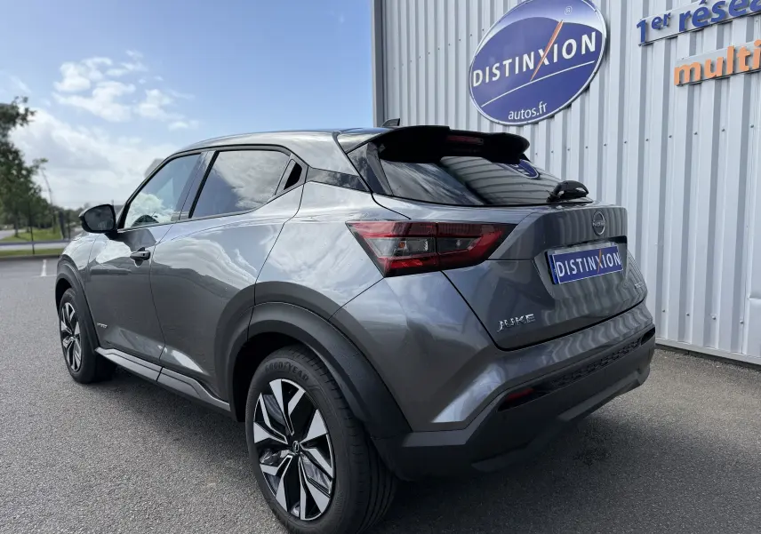 Vue 3/4 arrière droite du Nissan Juke Hybrid 143ch Business Edition gris squale métal avec jantes distinctives et vitres teintées.