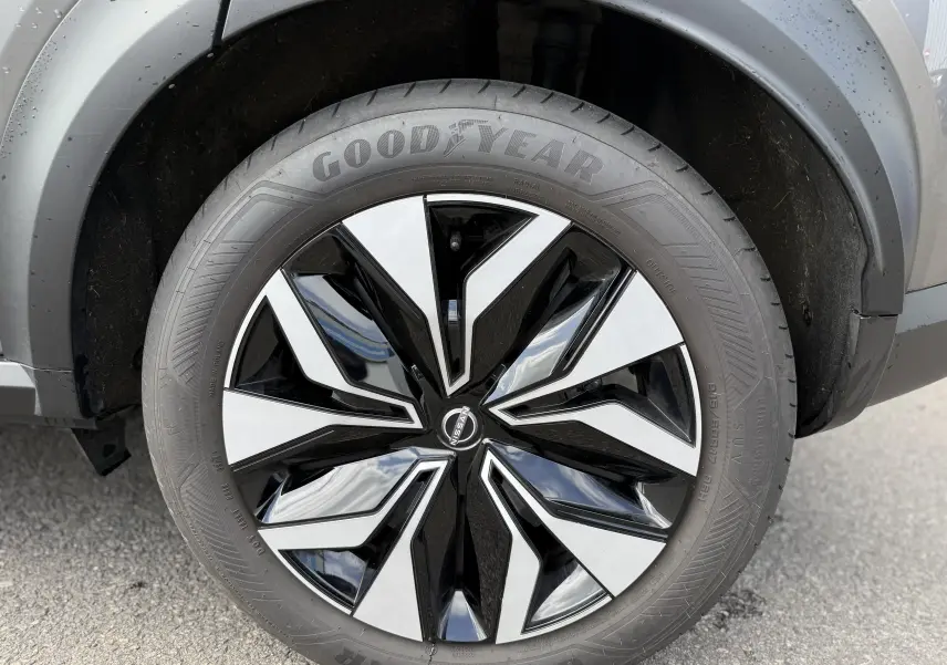 Gros plan sur la roue avant droite du Nissan Juke Hybrid 2025, jante bicolore noir et argent avec pneu Goodyear.