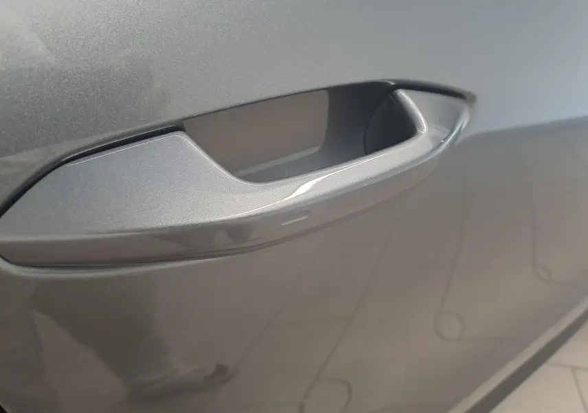 Poignée de porte gris graphite en gros plan sur un Skoda Kodiaq 2.0 TDI 150 DSG7 Selection 7 places, vue latérale.