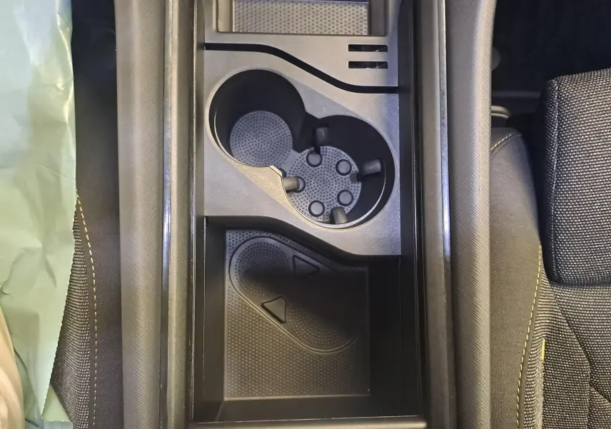 Vue plongeante sur la console centrale intérieure du Skoda Kodiaq gris graphite, avec porte-gobelets et rangement.