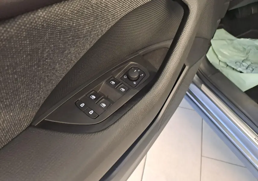 Vue rapprochée de la porte avant gauche du Skoda Kodiaq gris graphite 2025, avec commandes des vitres et rétroviseurs.