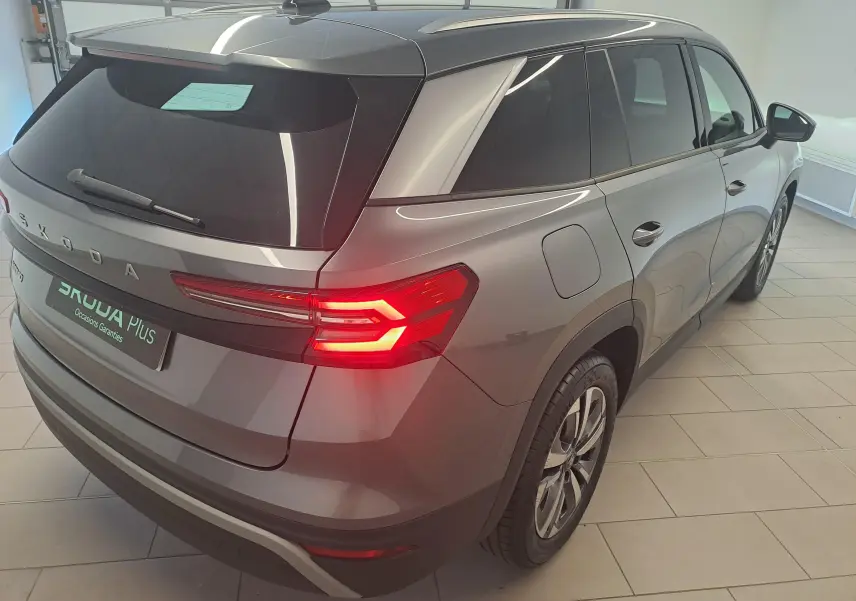Vue 3/4 arrière droite du Skoda Kodiaq gris graphite 2025 avec feux arrière allumés et jantes alliage.