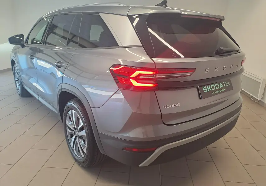 Vue 3/4 arrière droite du Skoda Kodiaq gris graphite 2025 avec feux arrière allumés et jantes alliage.